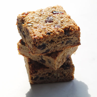 Stack of three maple and fruit flapjack bars on a white background